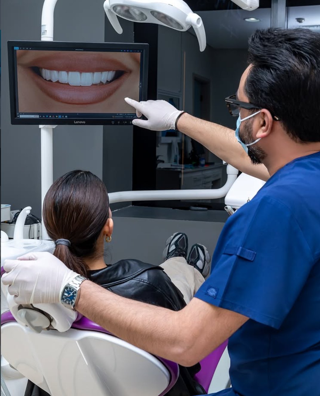 Dr. Mitul Desai showing a patient her digital smile design on a chairside screen